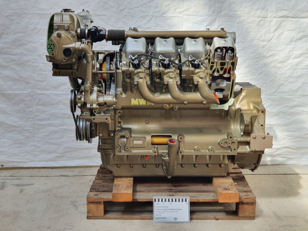 Ein historischer V8-Dieselmotor nach der Brandschadensanierung, sauber und konserviert in der Werkstatt.