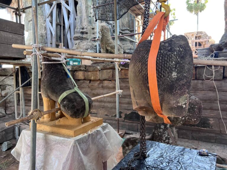Ein teilrestaurierter Löwe in Angkor Wat mit Tonmodell des Beins, Beispiel für Steinrestaurierung am Denkmal.